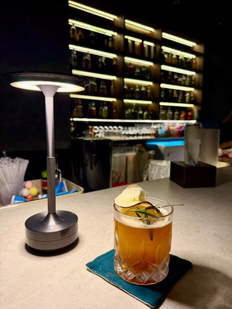 Signature cocktail with apple and rosemary at Tipsy Plus One