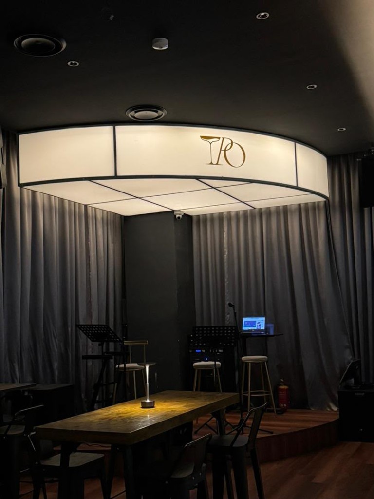 Tipsy Plus One live stage with curtains and warm lounge lighting